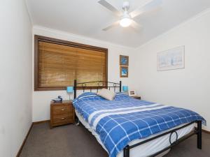 een slaapkamer met een bed en een plafondventilator bij Inlet Dreaming in Inverloch