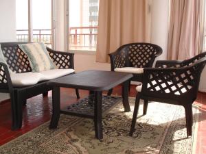 a living room with three chairs and a table and a couch at Los Olivos - Zand Properties in Benidorm