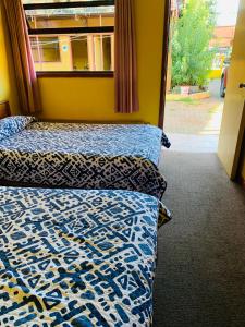 two beds in a room with a window at Hospedaje in Osorno