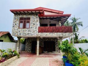 a house with a balcony on top of it at Muru's Place in Dickwella