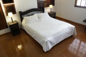 アルメニアにあるHotel Chalet El Castillo by Majuvaのベッドルーム1室(白いベッド1台、ランプ2つ付)