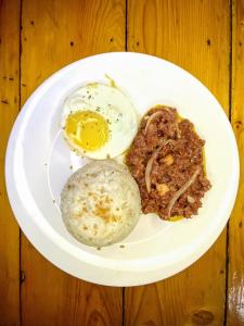 a plate of food with eggs and meat on a table at Rublin Hotel Cebu in Cebu City