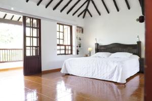 um quarto branco com uma cama grande e lençóis brancos em Hotel Chalet El Castillo by Majuva em Armênia