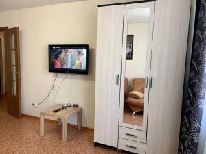 a room with a mirror and a tv on a wall at 2к Апартаменты на верхнем этаже на проспекте Ермакова, 10 in Novokuznetsk