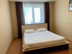 a small bed in a room with a window at 2к Апартаменты на верхнем этаже на проспекте Ермакова, 10 in Novokuznetsk