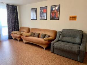 a living room with two couches and a couch and a chair at 2к Апартаменты на верхнем этаже на проспекте Ермакова, 10 in Novokuznetsk