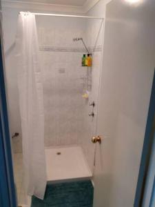 a bathroom with a shower with a white shower curtain at Cosy 2 bedroom Unit in a secure gated complex in Kalgoorlie