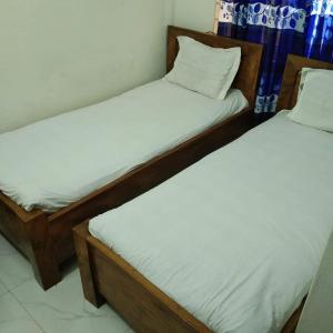 two twin beds in a room withthritisthritislictslictslicts at Hotel Bonolota international in Rājshāhi