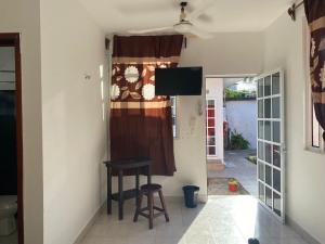 Zimmer mit einem Hocker und einem TV an der Wand in der Unterkunft Hotel villa carmita in Bacalar