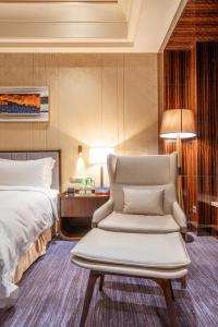 una camera d'albergo con letto e sedia di Chateau Star River Shaanxi a Xi'an