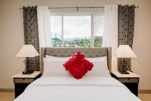 a bedroom with a bed with a red flower on it at Sta Barbara Residence Hotel in Cebu City