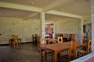 a dining room with tables and chairs and maps on the walls at Sinhagiri Villa in Sigiriya