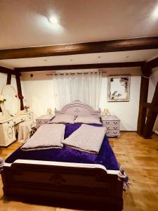 ein Schlafzimmer mit einem großen Bett mit violetter Bettwäsche in der Unterkunft Sancta Katharina in Rozvadov