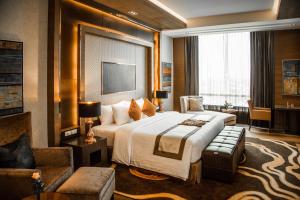 a bedroom with a large bed and a living room at The Grand Fourwings Convention Hotel Bangkok in Bangkok