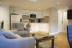een woonkamer met 2 stoelen en een tafel en een keuken bij Next to Olympic View golf course 2 bedroom private suite in Victoria