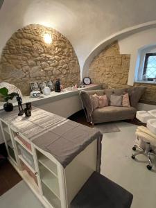 ein Wohnzimmer mit einem Sofa und einer Steinmauer in der Unterkunft Sancta Katharina in Rozvadov