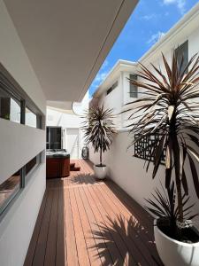 a balcony with two potted plants on a house at Ultra Stylish Fremantle Area in Fremantle