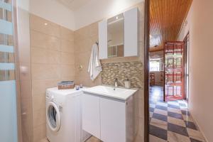 a bathroom with a washing machine and a sink at Villa Popi on the beach of Agios Gordios in Agios Gordios