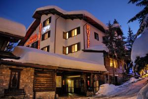 duży budynek z śniegiem na boku w obiekcie Hotel Edelweiss & SPA w mieście Cesana Torinese