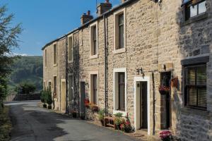 an old stone building with a street in front of it at Winskill Cottage in Settle
