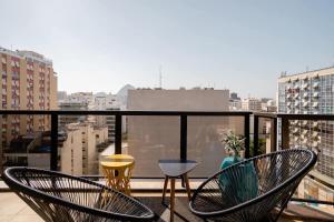 a balcony with chairs and a view of a city at LEBLON - TOP LOCATION - Serviced Apartment in Rio de Janeiro