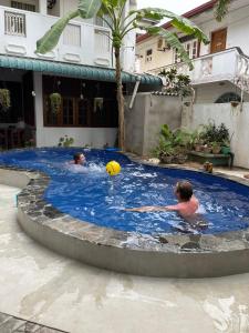 two people in a swimming pool with a ball at Yolanda Villa Negombo in Negombo