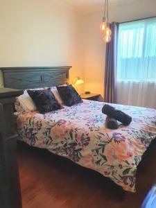 a bedroom with a bed with a floral comforter at LUXURIOUS Couples Escape, SPA BATH, Netflix, NBN in Victor Harbor