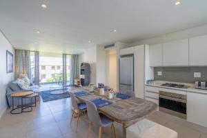 a kitchen and dining room with a table and chairs at Unit 215 Oceandune - Stunning & Modern Apartment in Sibaya