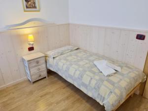 a small bedroom with a bed and a night stand at Ciapià in Campitello di Fassa
