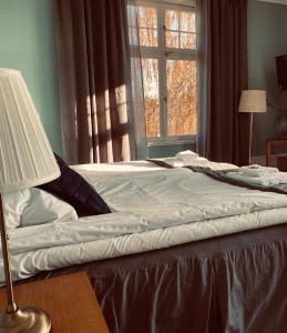 1 cama en un dormitorio con ventana en Bergsgården Hotell & Konferens, en Bergsgården