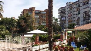 a hotel with a palm tree and some buildings at A Real Oasis In The City, in Palermo