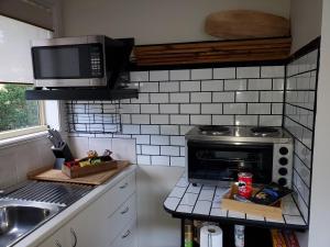 a kitchen with a microwave and a stove top oven at Lakeside Studio in Jindabyne