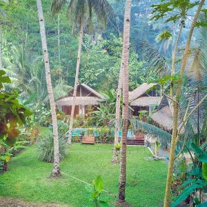 a resort with palm trees and a building at RNV Eco Resort Bungalows in Batukaras