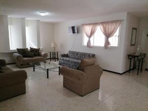 Sala de estar con 2 sofás y mesa en Amplio Departamento, Seguridad, Ubicacion Pb, en Querétaro