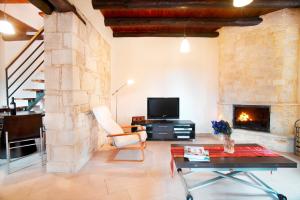 a living room with a fireplace and a tv at Villa Zourva in Zoúrva