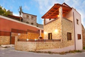 a house with a stone wall next to a building at Villa Zourva in Zoúrva