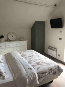 een witte slaapkamer met een bed en een dressoir bij 'T Achterhuys in Oostende