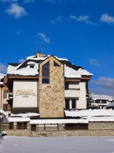 un bâtiment avec de la neige au-dessus dans l'établissement Hotel FAMIL - adults only, à Bansko