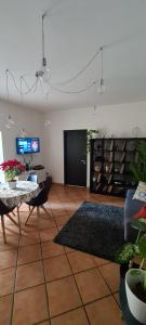 ein Wohnzimmer mit einem Tisch und einem TV in der Unterkunft Virginia House in Palermo