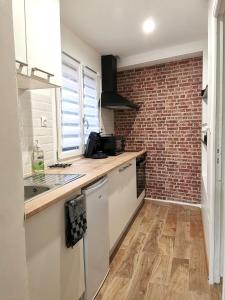 a kitchen with a counter and a brick wall at CHIC & WORK in Albert