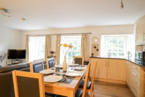 a kitchen and dining room with a table and chairs at Derwentwater Apartment in Keswick