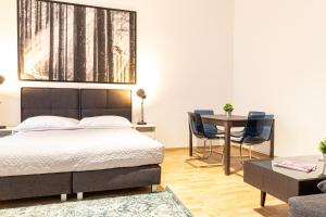 um quarto com uma cama, uma mesa e cadeiras em Apartment Landgutgasse em Viena