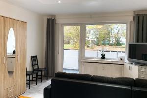 a living room with a couch and a large window at 3 room holiday flat in Hemer
