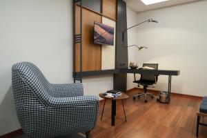 a living room with a chair and a desk at Expoist Hotel in Beylikduzu