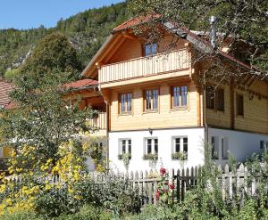 ein Holzhaus mit einem Zaun davor in der Unterkunft Ferienwohnung Klancnik in Bad Eisenkappel