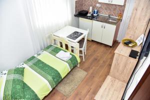a small bedroom with a bed and a kitchen at Apartmani Koko in Banja Luka