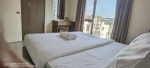 a bed with a white towel on it in a hotel room at Pool view + water theme park @swiss garden residence in Kuantan