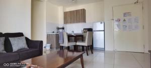 a living room with a couch and a table and a kitchen at Pool view + water theme park @swiss garden residence in Kuantan