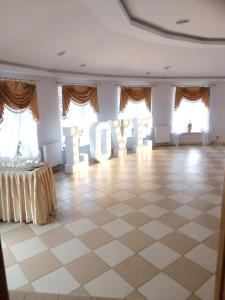 a large room with a tiled floor and windows at Zajazd Pod Jesionami in Nisko