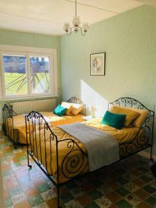 La Grange aux Tommies - Pays du Coquelicot في Bus Les Artois: سريرين في غرفة نوم مع جدران خضراء